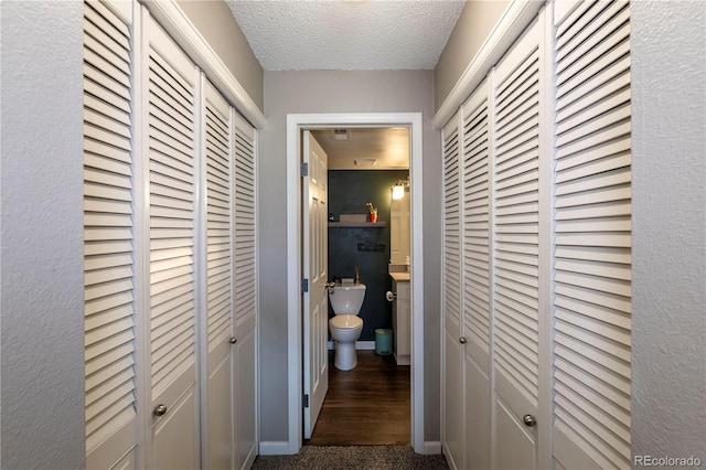 hall featuring a textured ceiling