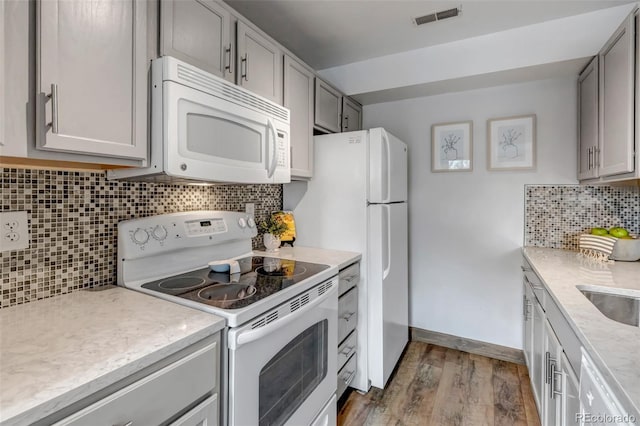 6711 S Ivy Way Unit A2, Centennial, CO 80112 - kitchen with white appliances, gray cabinetry, wood finished floors, and backsplash