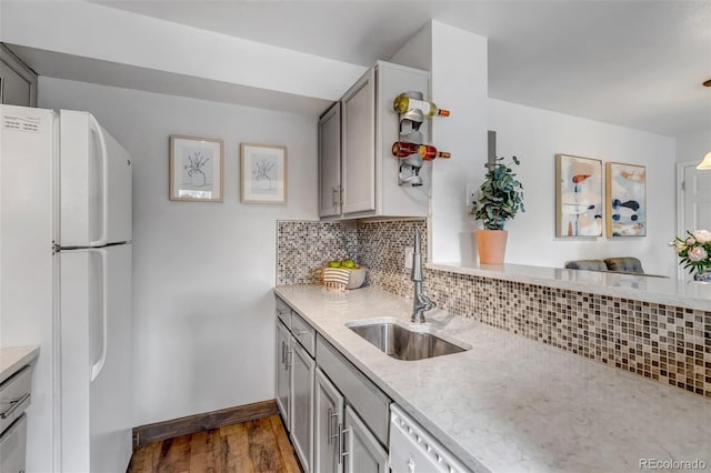 6711 S Ivy Way Unit A2, Centennial, CO 80112 - kitchen featuring white appliances, dark wood-type flooring, decorative backsplash, light stone countertops, and gray cabinetry