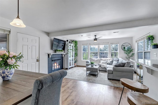 6711 S Ivy Way Unit A2, Centennial, CO 80112 - living area with wood finished floors, a tile fireplace, and a ceiling fan