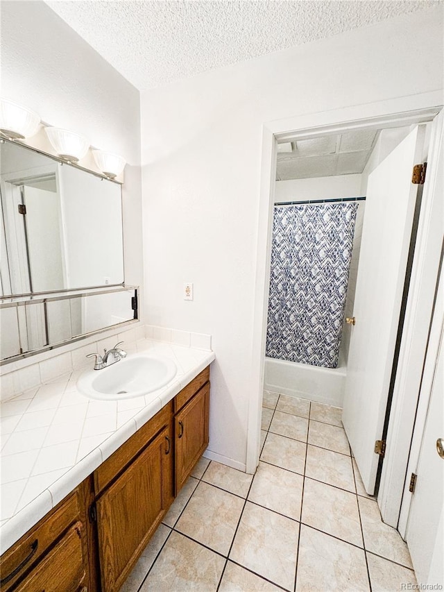 1700 S 6th Ave, Sterling, CO 80751 - full bath with vanity, tile patterned floors, a textured ceiling, and shower / bathtub combination with curtain