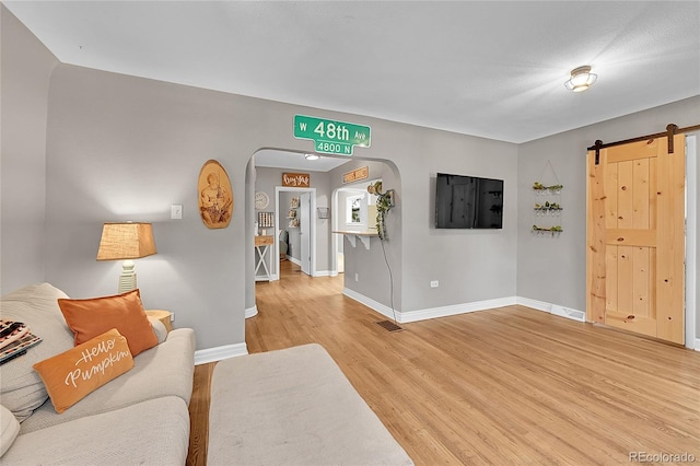 living room with light hardwood / wood-style floors and a barn door