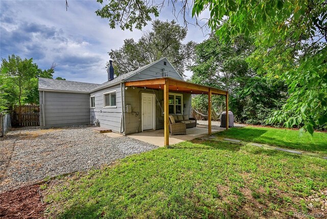 rear view of property featuring a patio and a yard