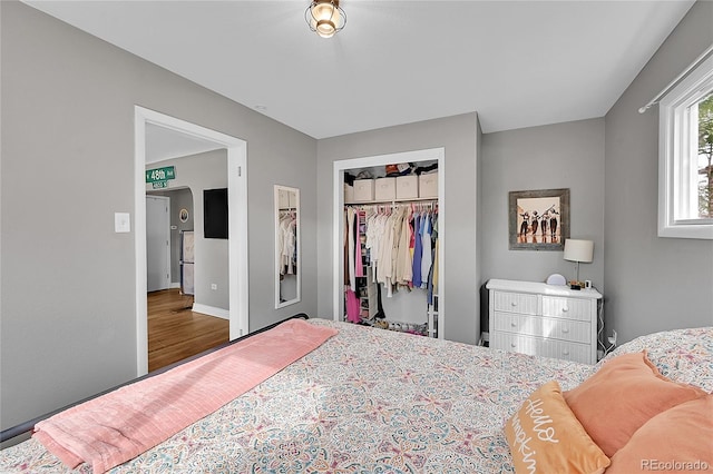 bedroom with dark wood-type flooring and a closet