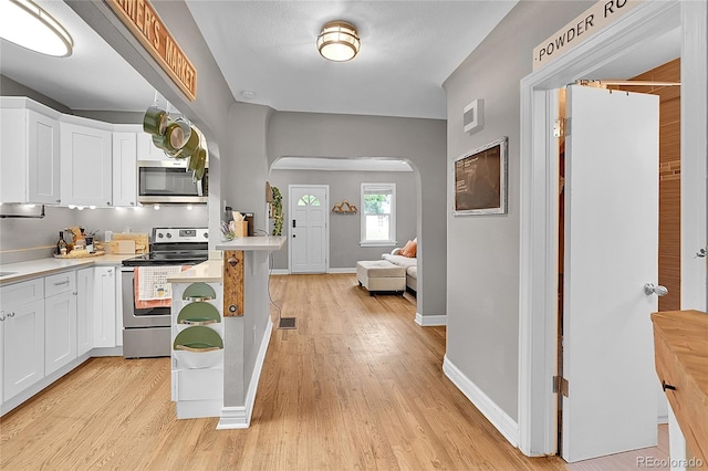 kitchen featuring appliances with stainless steel finishes, light hardwood / wood-style flooring, and white cabinets