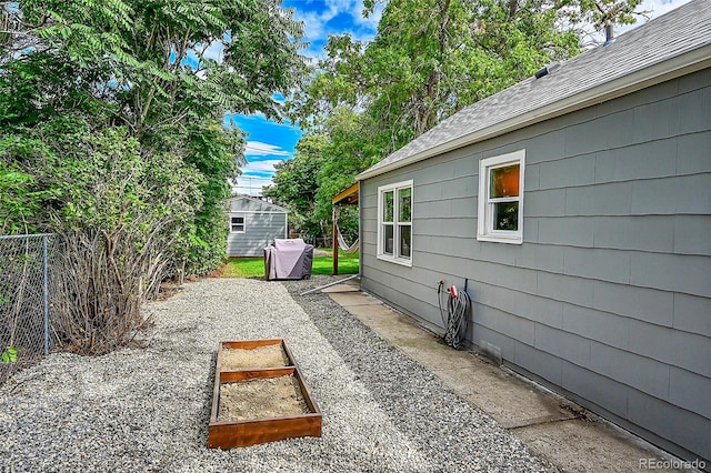 view of yard with a storage shed, fence, and an outbuilding