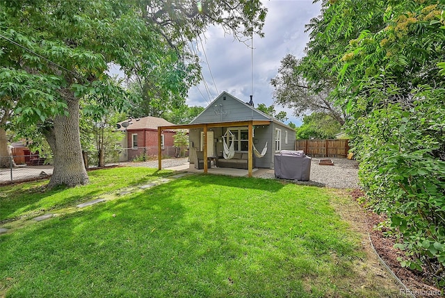 rear view of house featuring a patio area, a fenced backyard, and a lawn