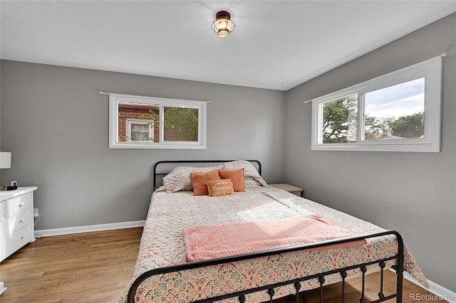 bedroom featuring baseboards and light wood finished floors