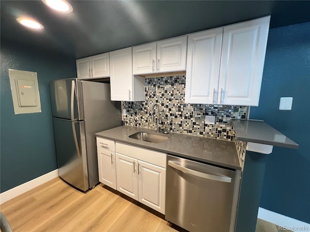 kitchen featuring white cabinets, appliances with stainless steel finishes, sink, electric panel, and light hardwood / wood-style flooring