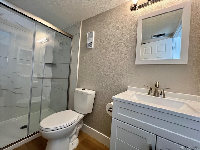 bathroom featuring wood-type flooring, toilet, a shower with door, and a textured ceiling