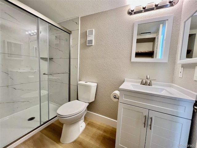 bathroom featuring toilet, hardwood / wood-style flooring, a textured ceiling, and walk in shower