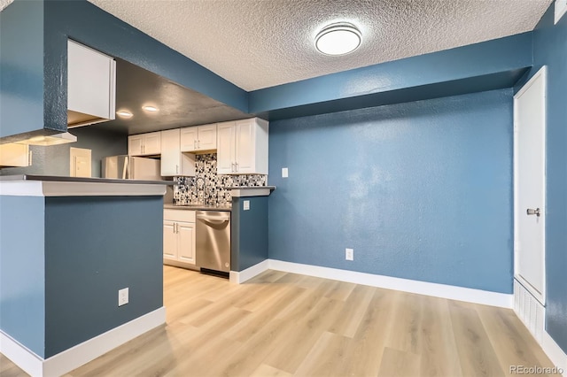 kitchen featuring dishwasher, white cabinetry, tasteful backsplash, and light wood-style flooring
