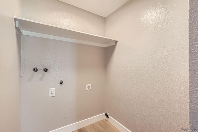 clothes washing area with light wood-type flooring, baseboards, washer hookup, electric dryer hookup, and laundry area
