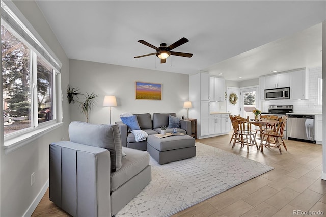 living room featuring ceiling fan and light hardwood / wood-style flooring