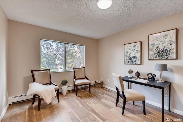 home office with light wood-type flooring and a textured ceiling