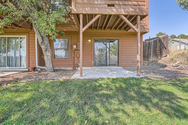 doorway to property with a patio area, a yard, and fence