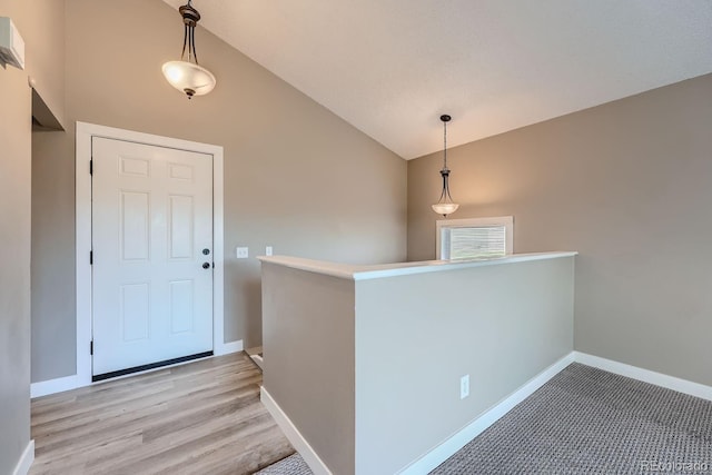 entryway with high vaulted ceiling, baseboards, and light wood-type flooring