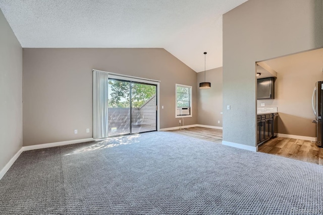 unfurnished room featuring light carpet, cooling unit, a textured ceiling, and baseboards