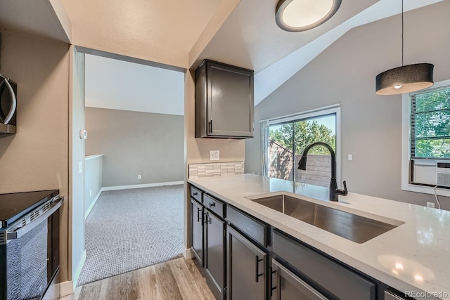 kitchen with a wealth of natural light, light stone counters, range with electric stovetop, and a sink