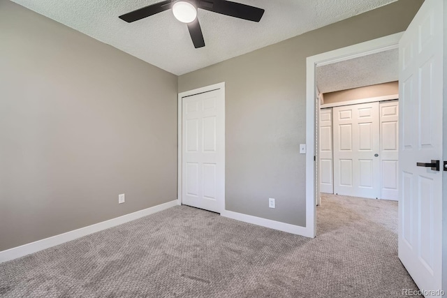 unfurnished bedroom featuring a textured ceiling, a ceiling fan, baseboards, and carpet floors