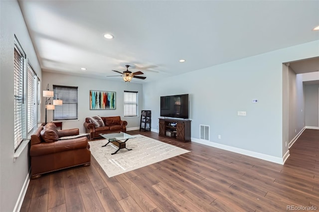 living room with dark hardwood / wood-style flooring and ceiling fan