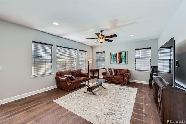 living room featuring dark wood-type flooring and ceiling fan