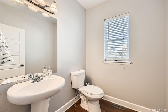 bathroom featuring toilet, sink, and hardwood / wood-style floors