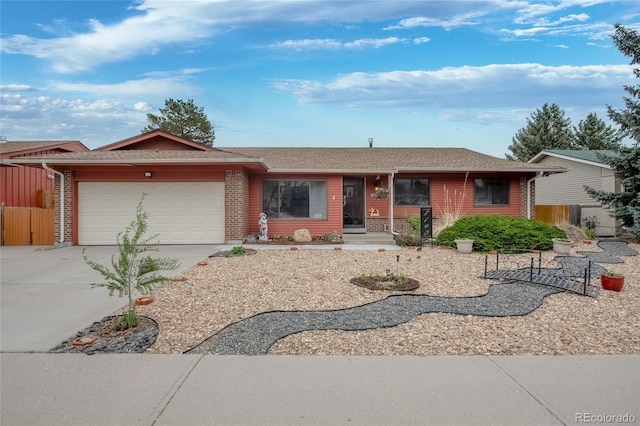 2140 S Youngfield St, Lakewood, CO 80228 - ranch-style house featuring roof with shingles, fence, an attached garage, brick siding, and driveway