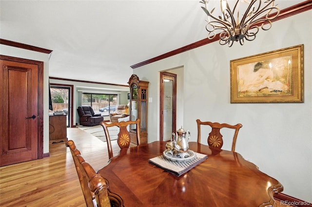 2140 S Youngfield St, Lakewood, CO 80228 - dining space with crown molding, a chandelier, and light wood-style flooring