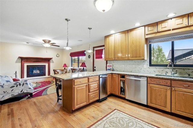 2140 S Youngfield St, Lakewood, CO 80228 - kitchen featuring light stone countertops, dishwasher, a sink, a peninsula, and light wood-style floors