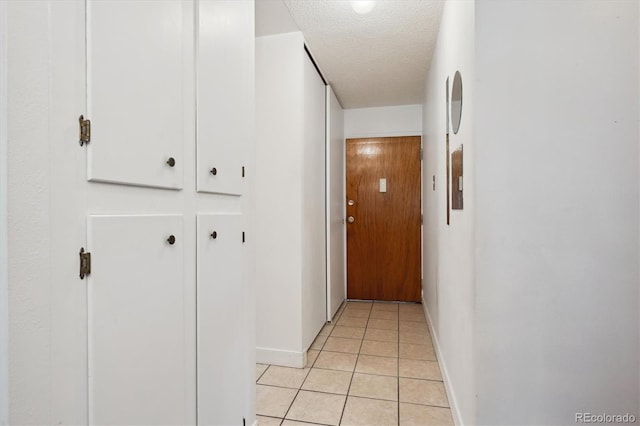710 S Clinton St Unit 1A, Denver, CO 80247 - hallway with baseboards, a textured ceiling, and light tile patterned floors