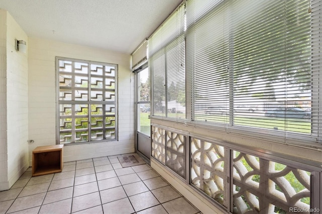710 S Clinton St Unit 1A, Denver, CO 80247 - unfurnished sunroom featuring tile patterned floors and a textured ceiling