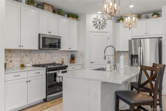 8132 Mt Harvard Rd, Littleton, CO 80125 - kitchen with appliances with stainless steel finishes, a chandelier, light countertops, a kitchen breakfast bar, and white cabinets