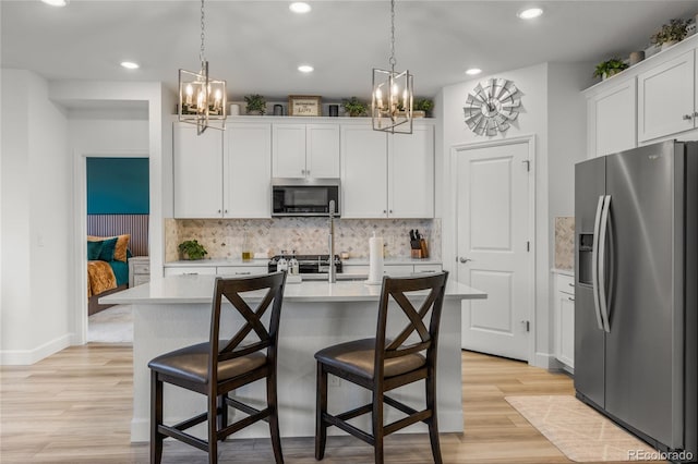 8132 Mt Harvard Rd, Littleton, CO 80125 - kitchen with stainless steel appliances, a chandelier, recessed lighting, light countertops, and decorative backsplash