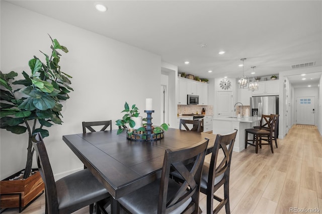 8132 Mt Harvard Rd, Littleton, CO 80125 - dining room featuring recessed lighting, light wood-style flooring, a chandelier, and baseboards