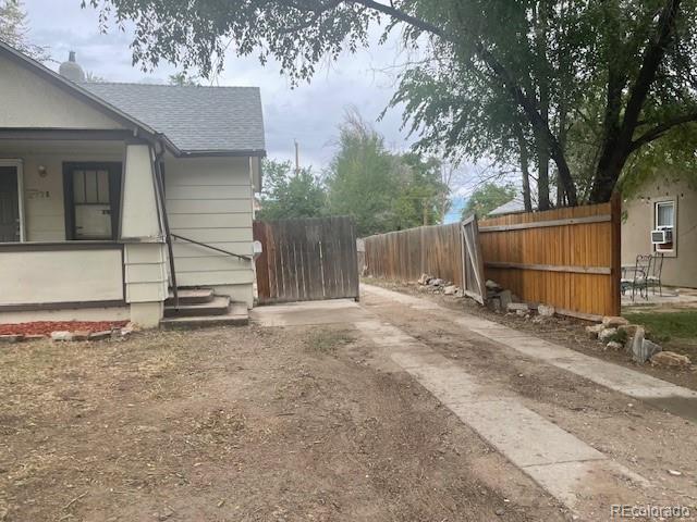 2771 W 1st Ave, Denver, CO 80219 - view of side of home featuring a shingled roof and fence