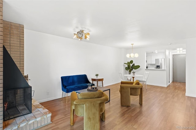 living room featuring hardwood / wood-style flooring, a wood stove, and a notable chandelier