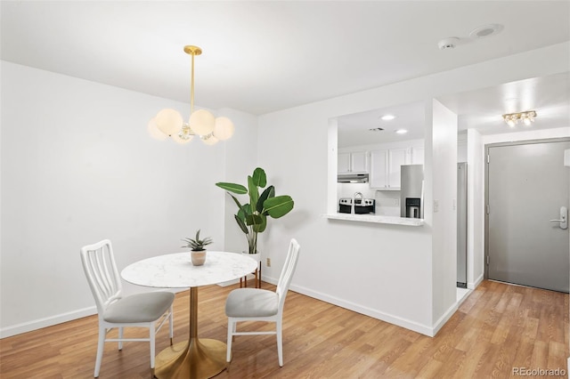 dining room featuring an inviting chandelier and light wood-type flooring