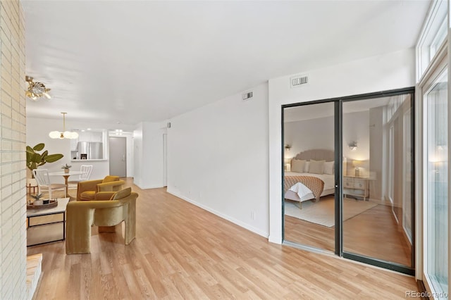 living room with a chandelier and light hardwood / wood-style flooring