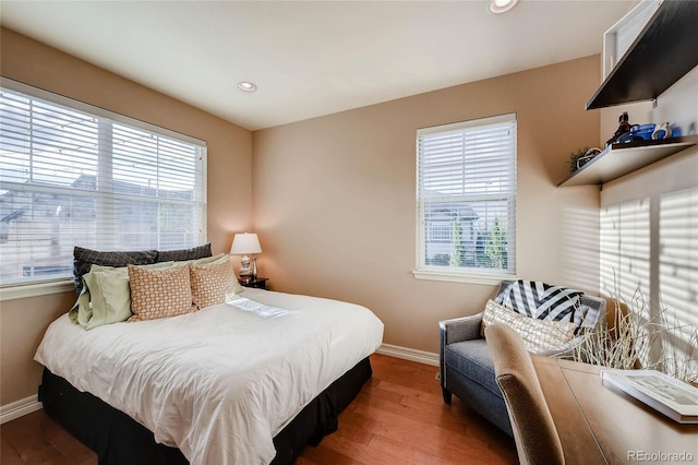 bedroom with recessed lighting, wood finished floors, and baseboards