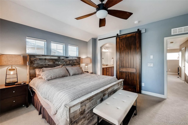 bedroom featuring a barn door, visible vents, arched walkways, baseboards, and light colored carpet