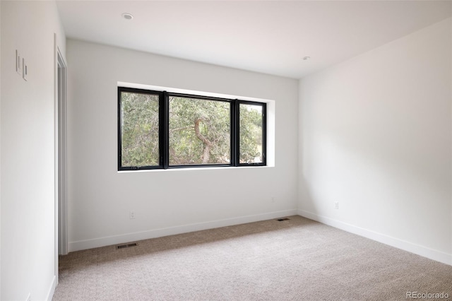 spare room featuring light colored carpet