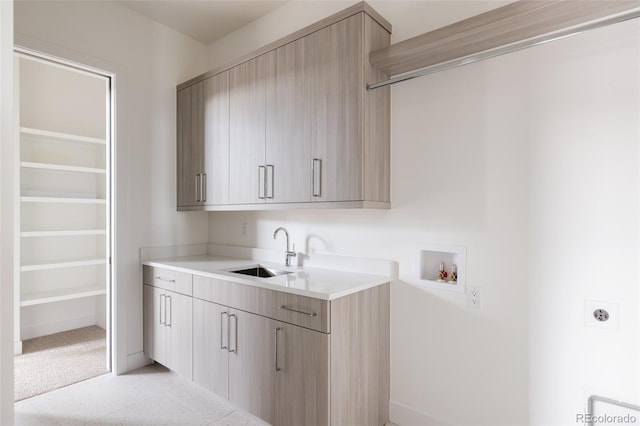 laundry area with light colored carpet, electric dryer hookup, washer hookup, cabinets, and sink