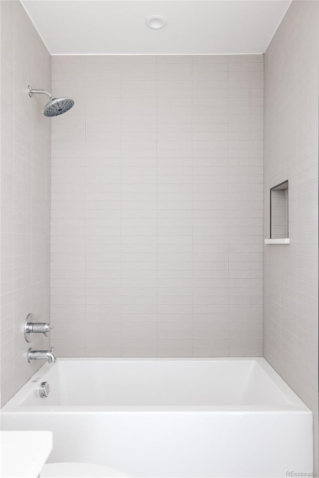 bathroom featuring tiled shower / bath