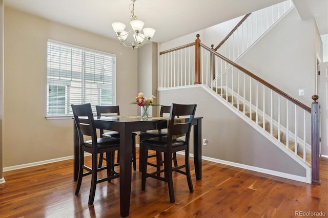dining room with a chandelier, wood finished floors, stairs, and baseboards