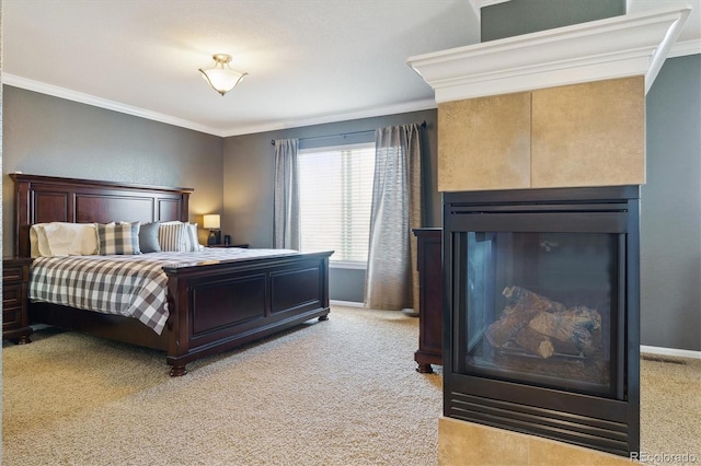 bedroom with crown molding, light colored carpet, baseboards, and a glass covered fireplace