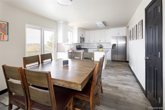 dining area with light wood finished floors and baseboards