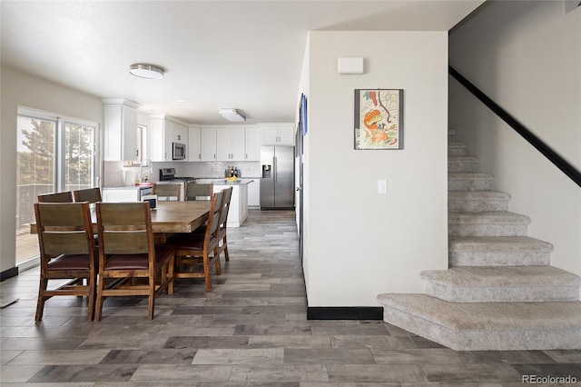 dining room featuring stairs and wood finished floors
