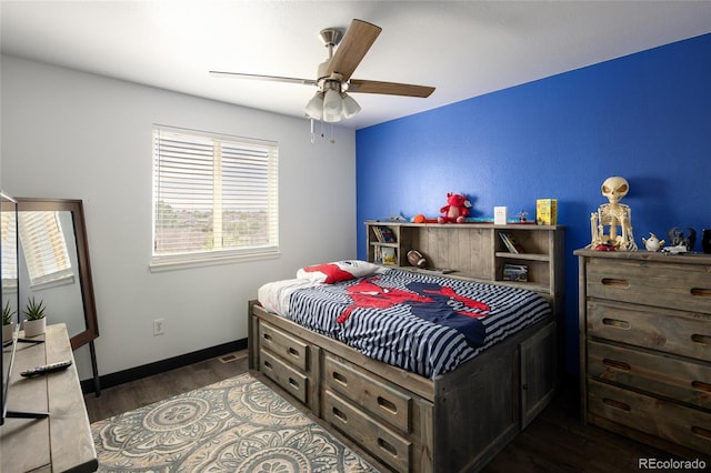 bedroom with dark wood-type flooring, a ceiling fan, and baseboards