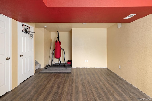 unfurnished room featuring wood finished floors and a textured wall